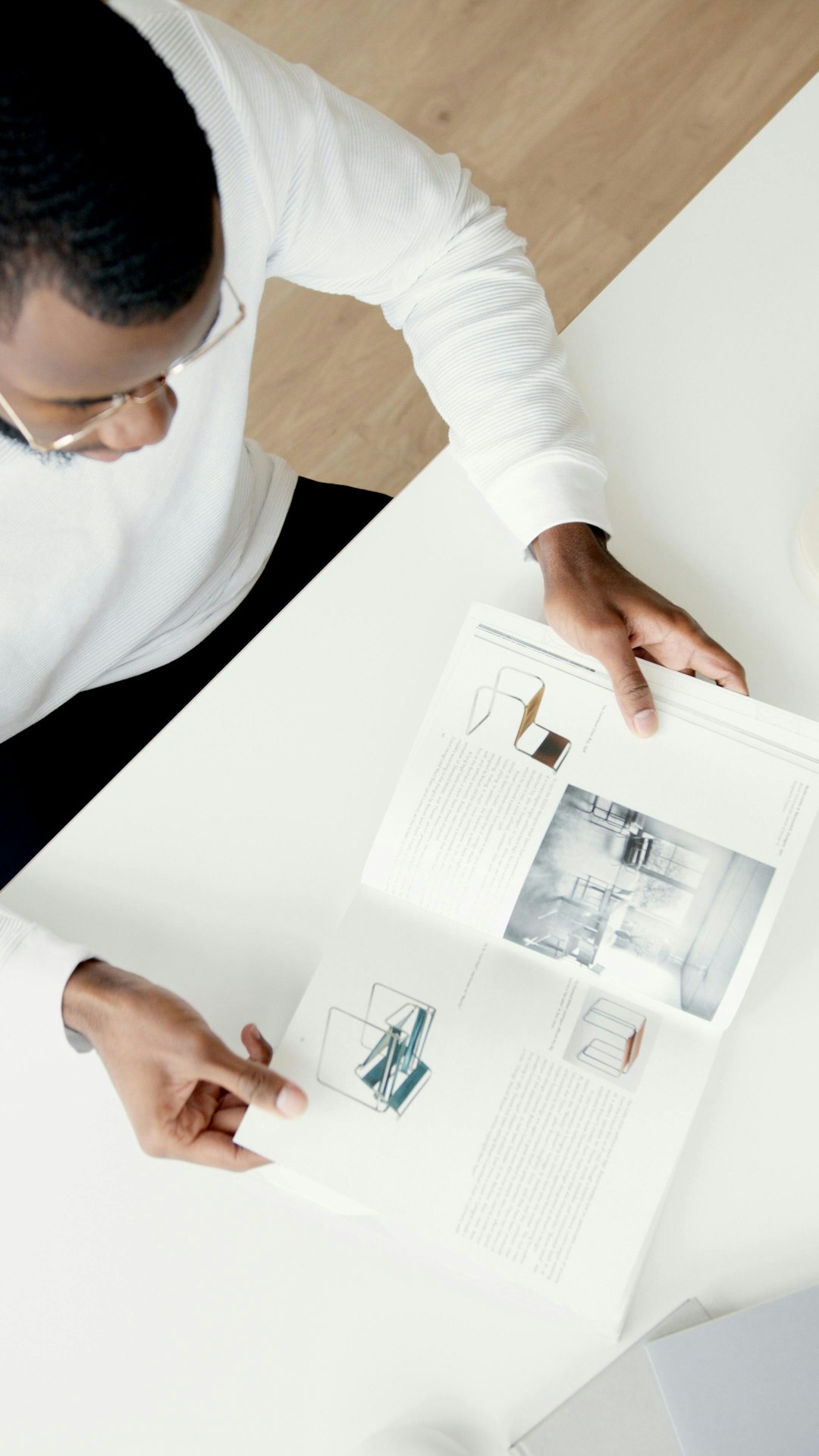 services-04 a-man-reads-a-magazine-at-a-white-table-1jk3-qzx4is