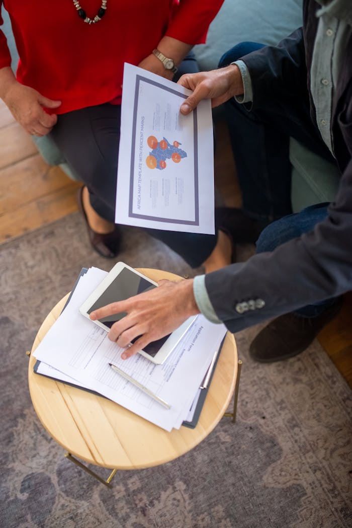 Overhead view of a business meeting with documents and a tablet, showcasing collaboration.